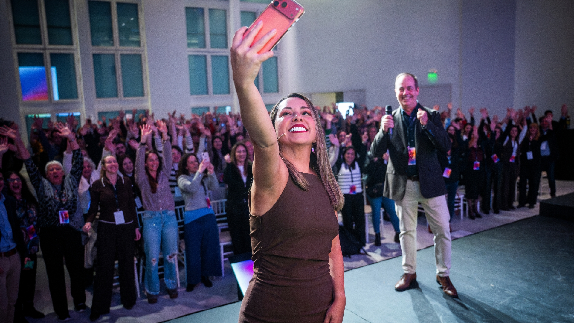 Apresentadora tirando uma selfie com os participantes no lançamento da RINGANA no Faena Art Center, Buenos Aires.
